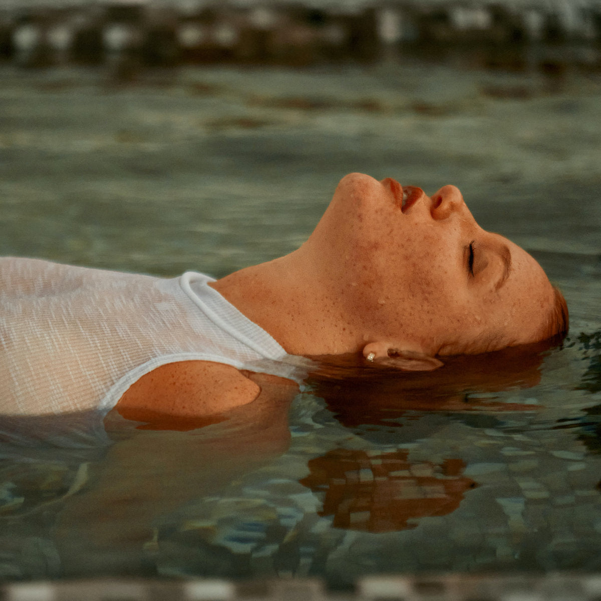 Frau floated im Wasser und entspannt